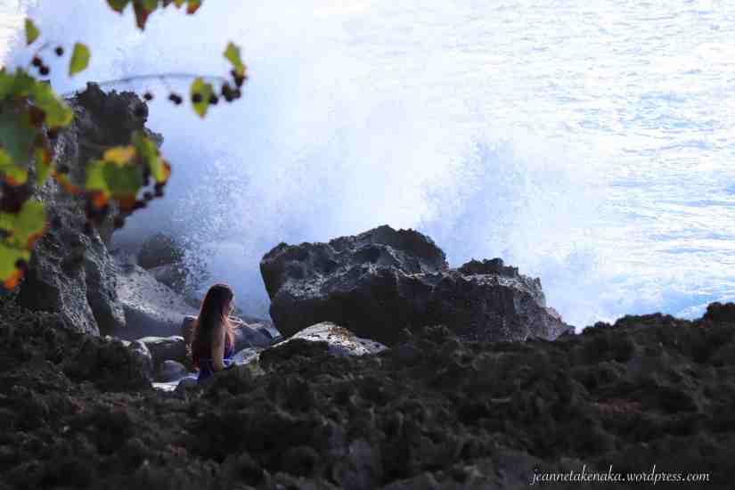 woman in the rocks near waves
