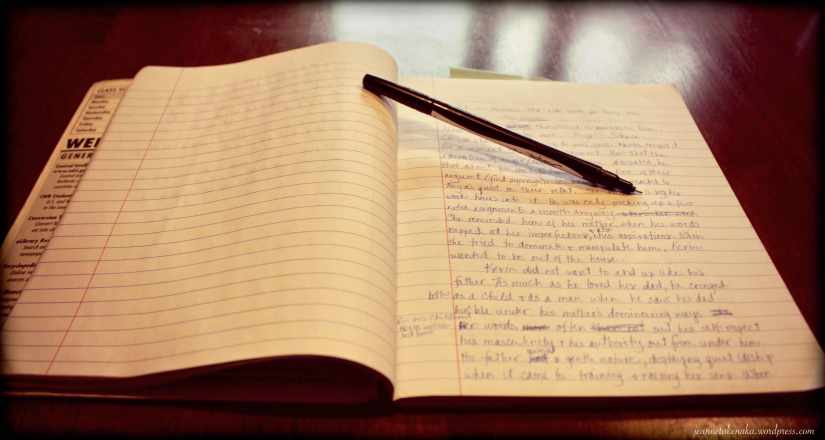 A picture of a journal with hand writing and scribbles and a pen propping open the pages